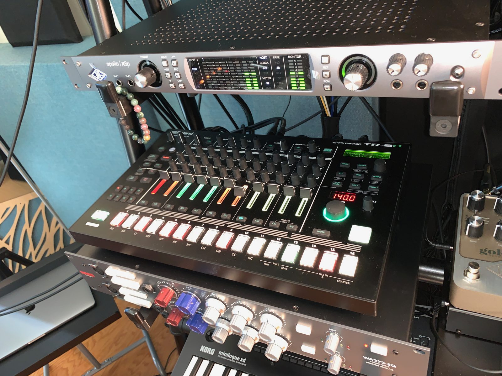 Rack-mounted audio gear and a drum machine in the studio
